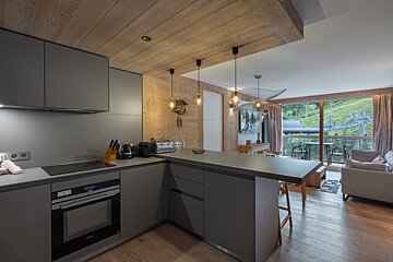 A kitchen with gray cabinets and a black stove top oven