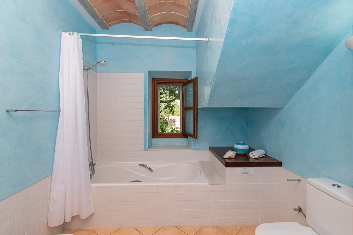 A bathroom with blue walls and a bathtub