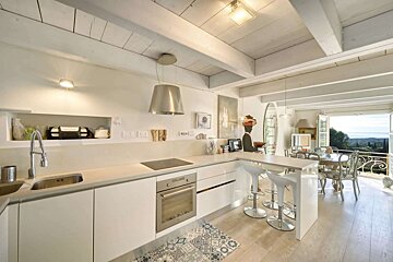 A kitchen with white cabinets and a stove top oven