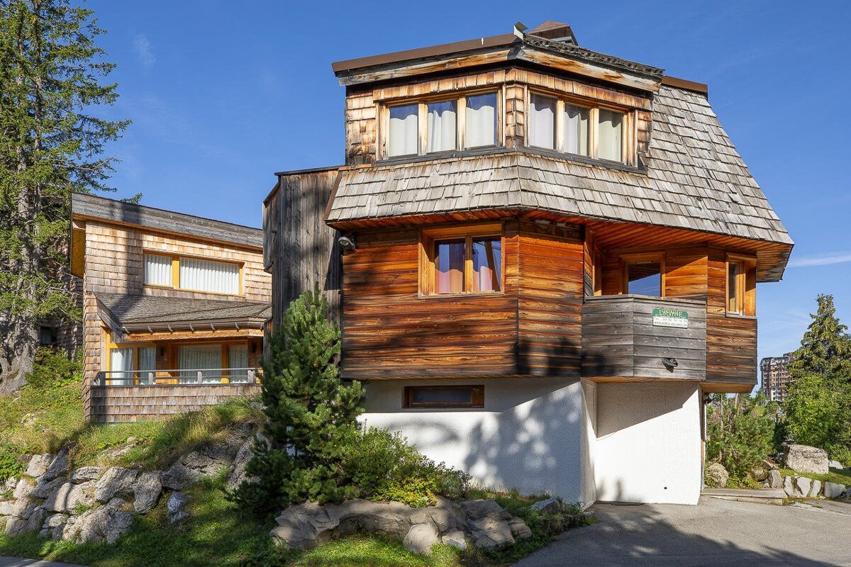 A wooden house with a sign that says ' alquiler ' on it