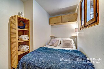 A bedroom with a bed and a knight frank logo