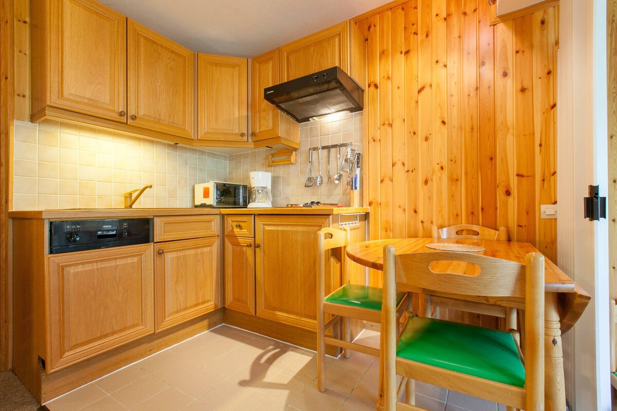 A kitchen with wooden cabinets and a dishwasher that says miele