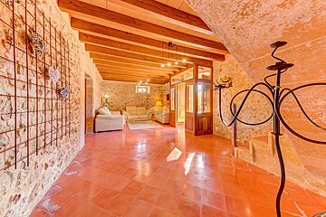 A hallway leading to a living room with wooden beams