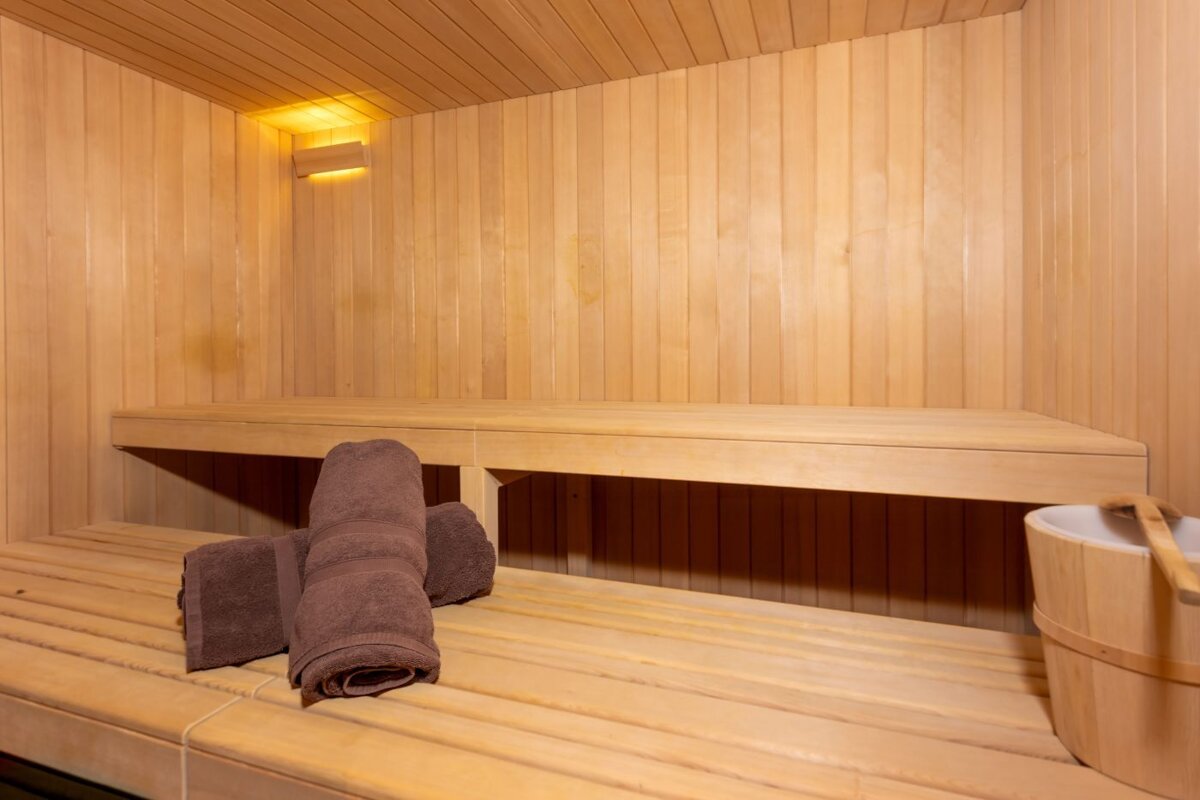 A wooden bench in a sauna with two towels on it