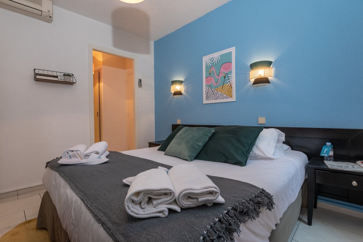 A bedroom with a picture of a flamingo on the wall