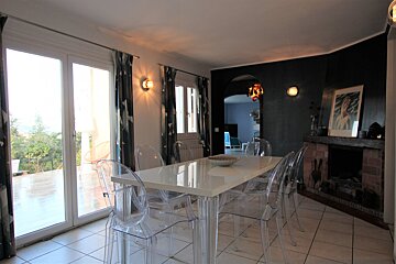 A dining room with a white table and clear chairs