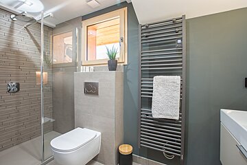 A bathroom with a toilet and a towel rack