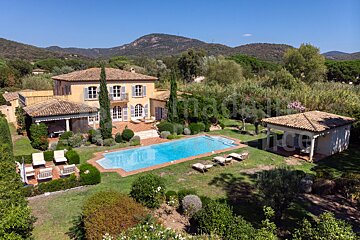 An aerial view of a large house with a large swimming pool