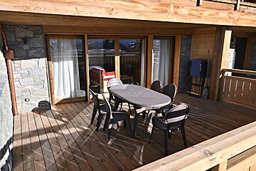A wooden deck with a table and chairs on it
