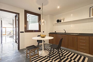 A kitchen with a table and chairs and a striped rug