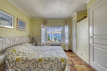 A bedroom with a bed and two pictures on the wall