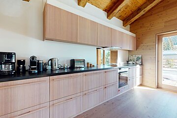 A kitchen with wooden cabinets and black counter tops
