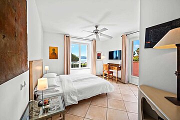 A bedroom with a large bed a desk and a television