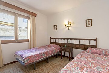 A bedroom with two beds and two pictures on the wall