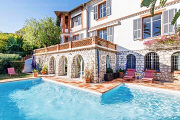 A large house with a large swimming pool in front of it