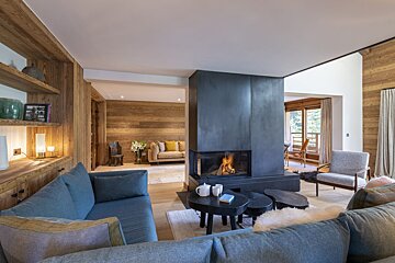 A living room with a fireplace and a blue couch