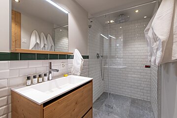 A bathroom with a sink and a walk in shower