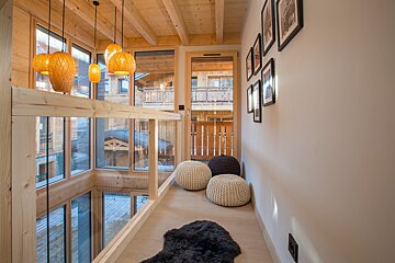 A hallway with a lot of windows and ottomans
