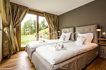 A bedroom with two beds and a sliding glass door