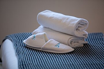A pair of white slippers with the word swan on them