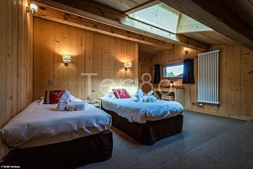 A bedroom with two beds and the word tango on the bottom