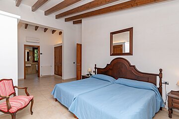A bedroom with two beds and a mirror on the wall