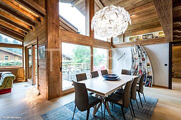 A dining room with a table and chairs and a chandelier