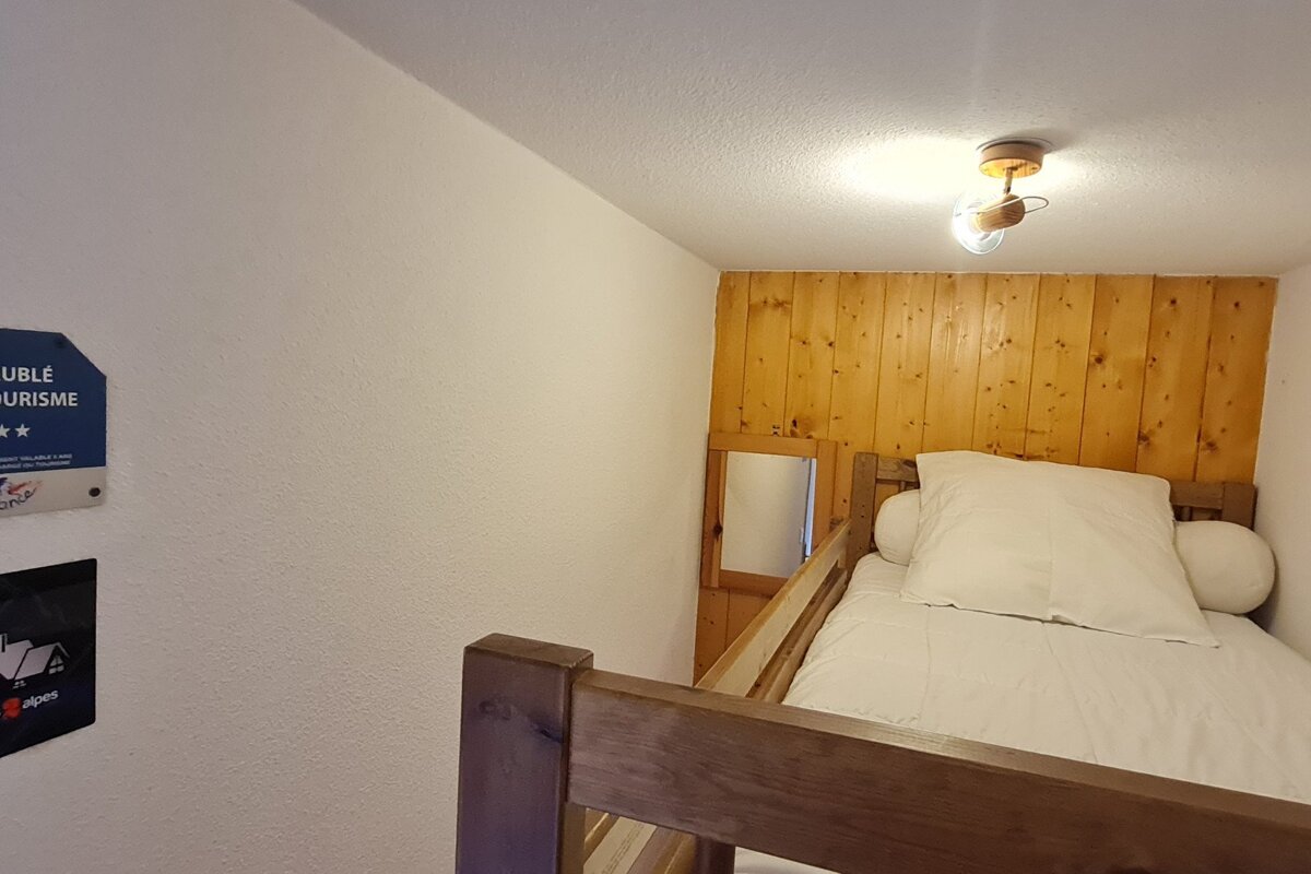 A small room with a bed and a sign that says 