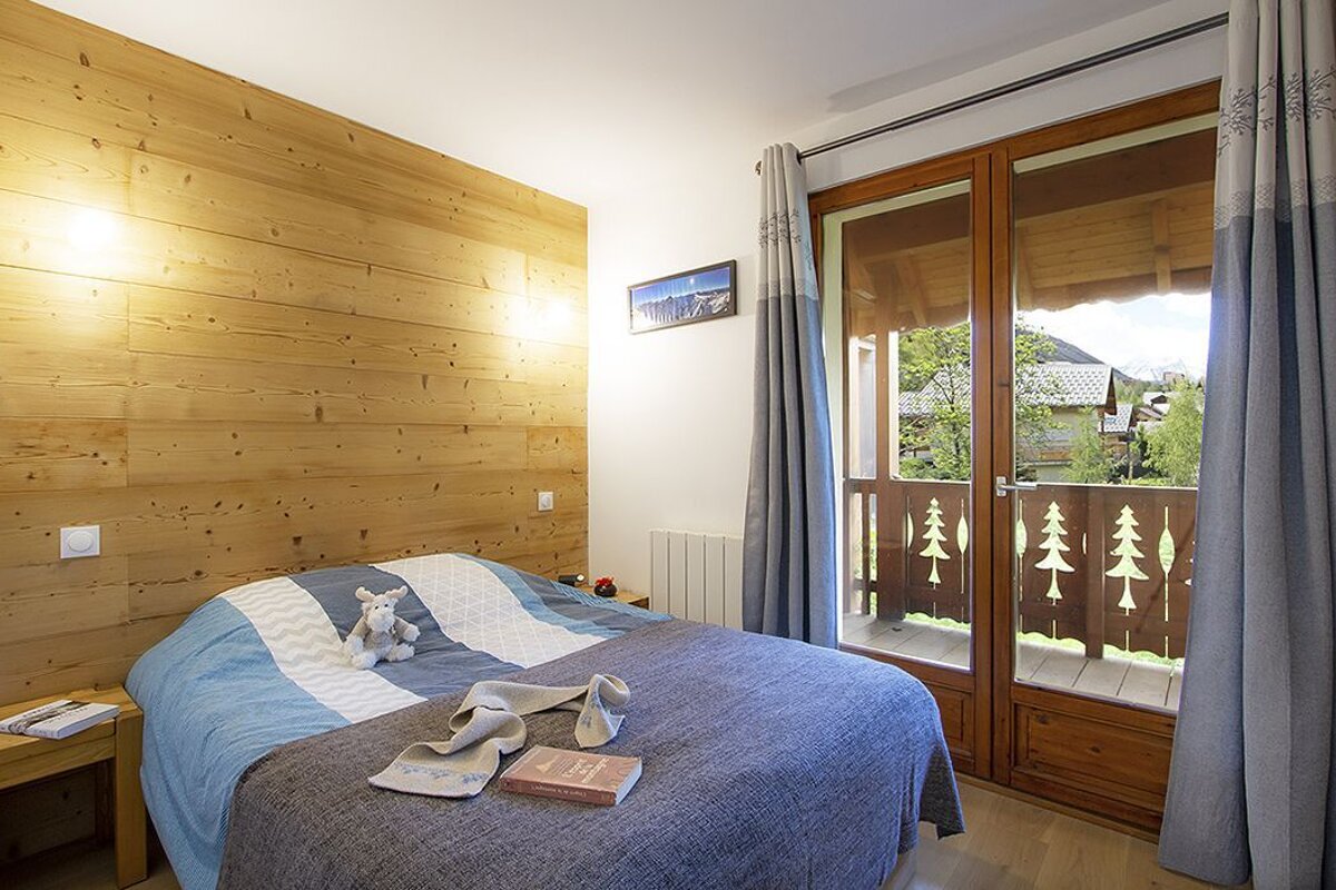 A bedroom with a bed a book and a picture on the wall