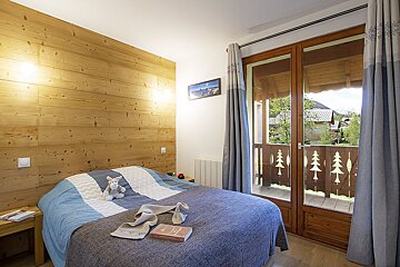 A bedroom with a bed a book and a picture on the wall