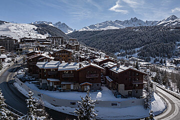 A snowy landscape with mountains in the background