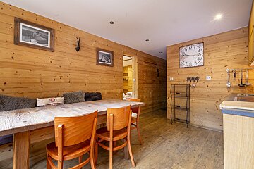 A kitchen with a wooden table and chairs and a clock on the wall