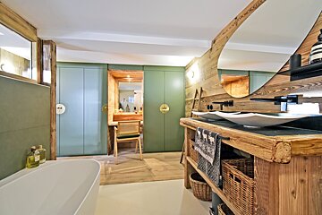 A bathroom with two sinks and a bottle of aesop