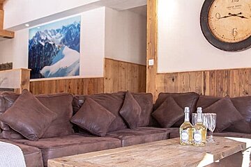 A living room with a couch and a clock that has the number 6 on it