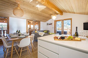A kitchen with a cutting board with grapes and cheese on it