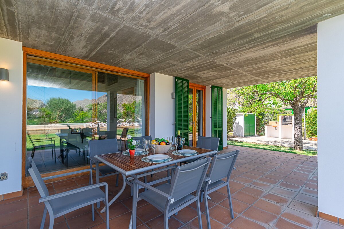 A patio with a table and chairs and a bowl of fruit