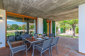 A patio with a table and chairs and a bowl of fruit