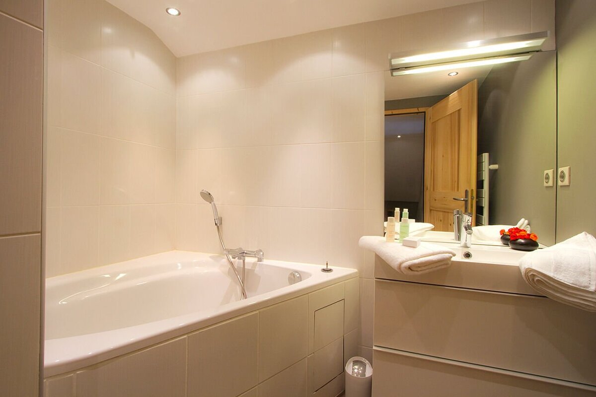 A bathroom with a bathtub a sink and a mirror