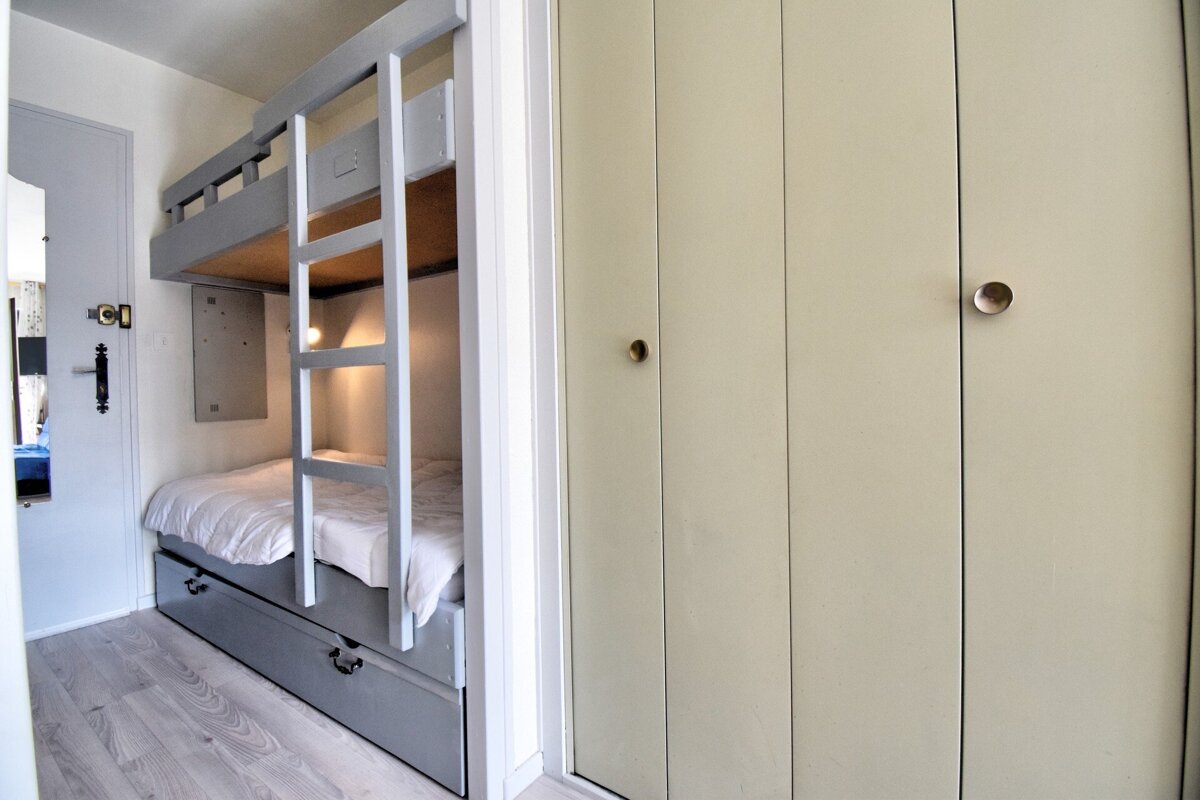 A bunk bed is built into a wall next to a closet
