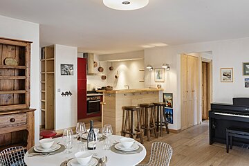 A dining room with a bottle of wine on the table
