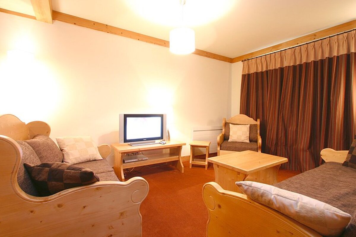 A living room with wooden furniture and a flat screen tv