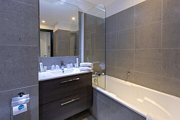 A bathroom with a sink and a bathtub and a sign that says aqua