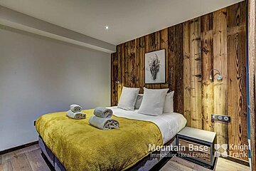 A bedroom with a bed and a sign that says mountain base