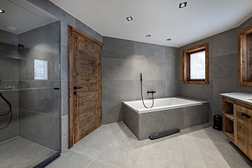 A bathroom with a bathtub and a wooden door