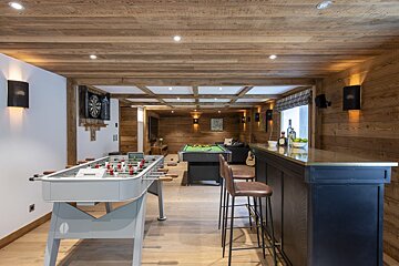 A game room with a pool table and a foosball table