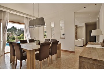A dining room with a table and chairs and a lamp
