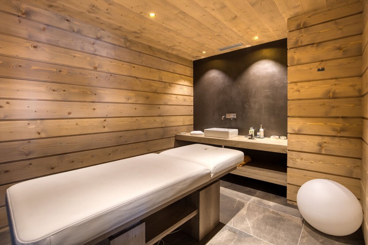A massage table in a room with wooden walls