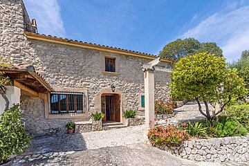 A stone house with a sign that says ' alquiler ' on it