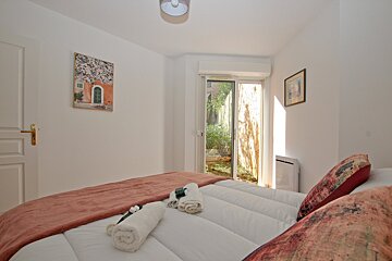 A bedroom with a painting on the wall above the bed
