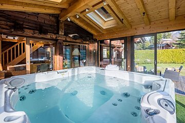 A hot tub in a house with a skylight above it